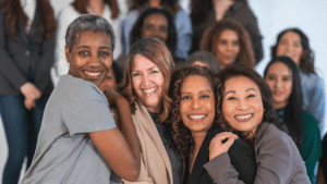 a group of women of different ages and races smiling at camera